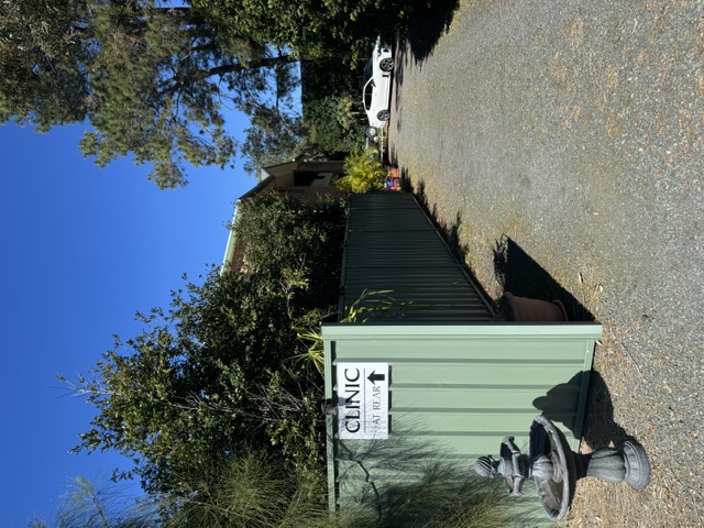 Clinic exterior at Tea Gardens showing entrance pathway and clinic at rear sign